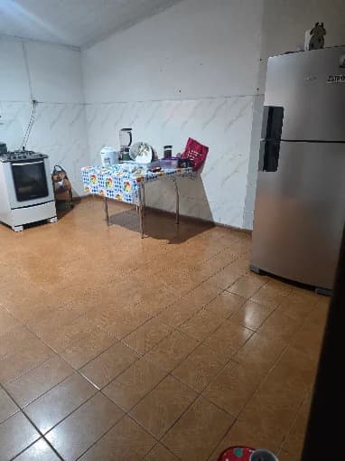 Cozinha ampla e organizada, com fogão, geladeira e bancada de apoio